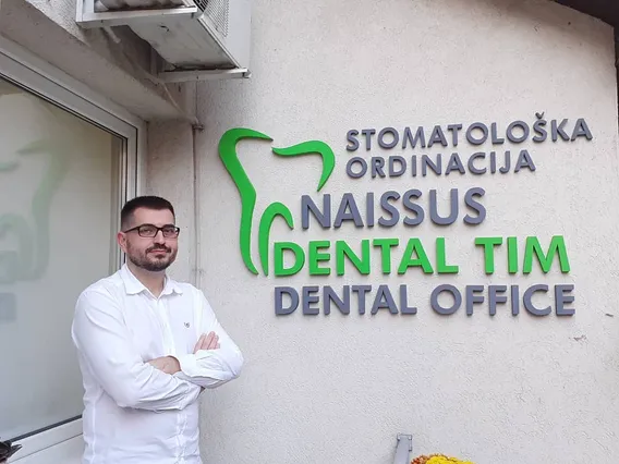 Dr Dalibor Stojković ispred natpisa ordinacije Naissus Dental Tim